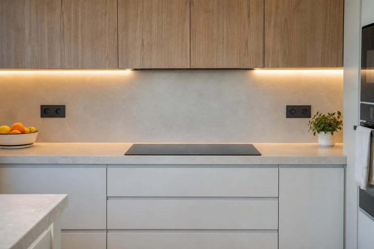 Cocina con iluminación bajo mueble y enchufes nuevos sobre la encimera