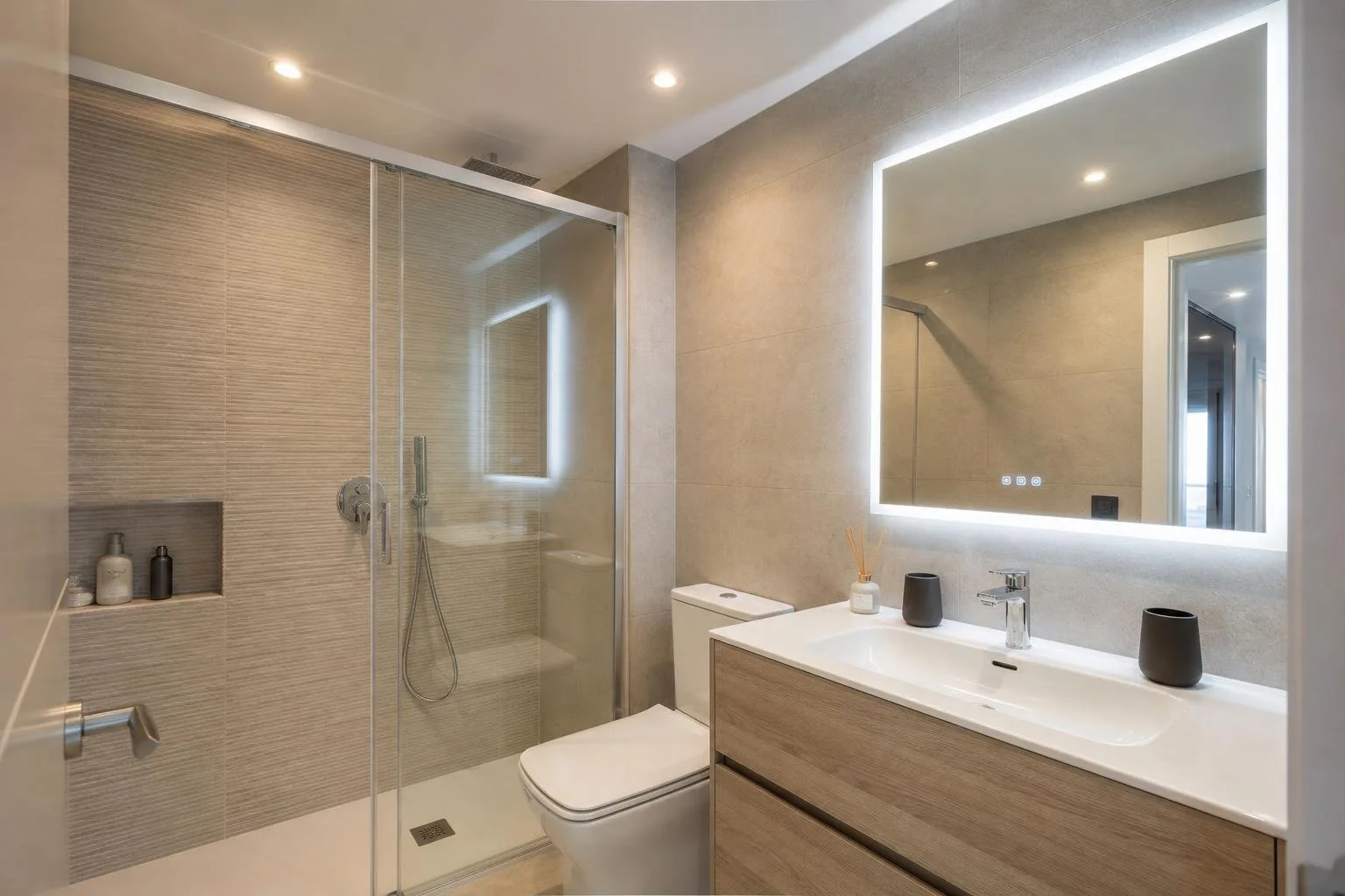 Baño con luz LED en el espejo y focos de techo